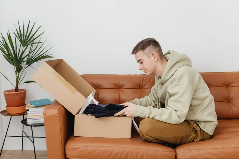 Persona abriendo un paquete sobre una mesa en casa